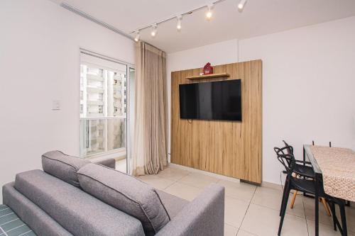 a living room with a couch and a flat screen tv at Deluxe Independência 915 Central Piscina/Academia in Juiz de Fora