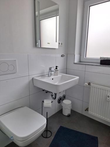 a bathroom with a sink and a toilet and a mirror at Moderne Wohnung in Krefeld in Krefeld