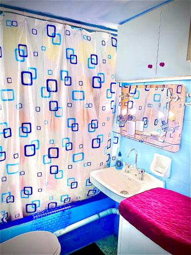 a bathroom with a sink and a shower curtain at Modern Comfort Minutes from Plaka & Monastiraki in Athens