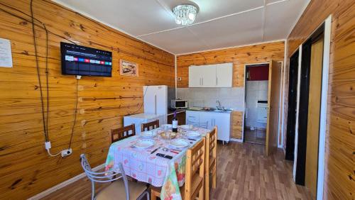 a dining room with a table and a kitchen at El Viejo in Río Mayo