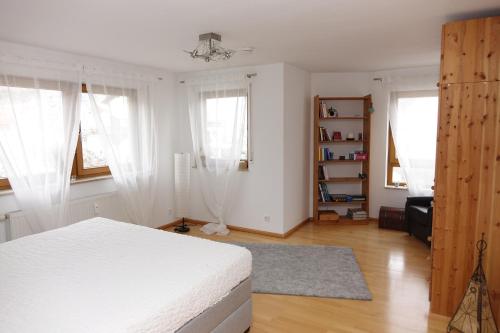 a bedroom with a white bed and two windows at Fewo Anna - ruhig gelegen, mitten in der Natur, unmittelbar am Neckarsteig in Neckarsteinach