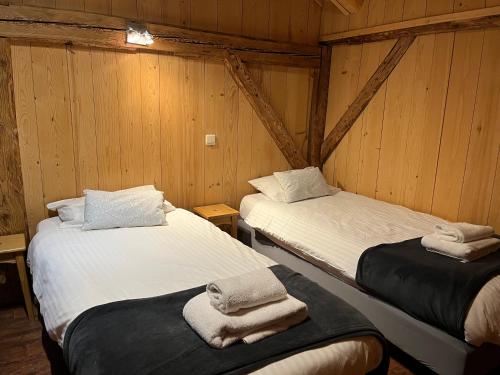 two beds in a room with wooden walls at Chalet Les Lanchettes in Morzine