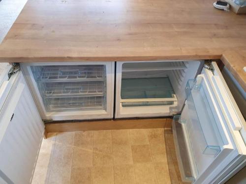 an empty refrigerator with its doors open in a room at Luxury Lodge at billing aquadrome in Northampton