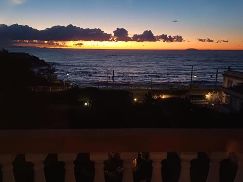 a sunset over the ocean with people watching at Sea-front loft in Liberty villa in Castiglioncello