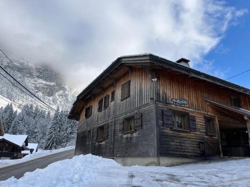 a wooden cabin in the snow with a mountain at Chalet Les Lanchettes in Morzine