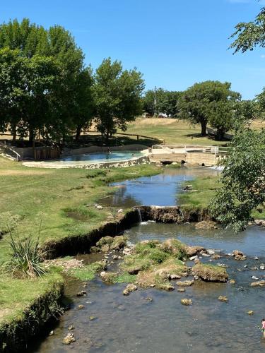 a stream of water with rocks in a field at Duplex 1 Villa Ramallo in Estación Ramallo