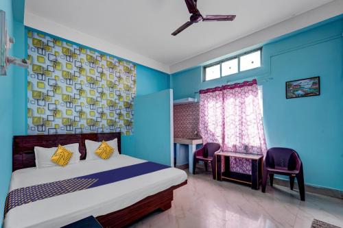a bedroom with a bed and a blue wall at Hotel O Home Trimurti guest house in Guwahati