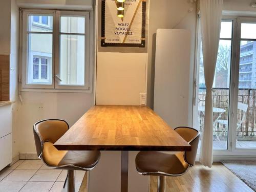 une table à manger avec deux chaises et un réfrigérateur dans l'établissement Appartement calm au maison des arts de Plessis, au Plessis-Robinson