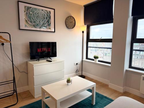 a living room with a tv and a table at Luxury Super-King Bed Flat in Town Centre in Northampton