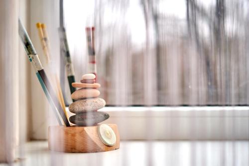 a stack of stones sitting on a table next to brushes at Tokyo Vibes - Private Sleeping Pods Hostel, Self check-in in Vilnius