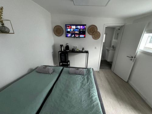 a bedroom with a bed and a tv on the wall at ART House /15 Min. Düsseldorf Messe,Airport & City in Meerbusch