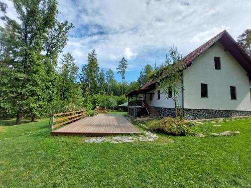 a house with a wooden bridge next to a yard at Chata BABÍ LOM in Lelekovice