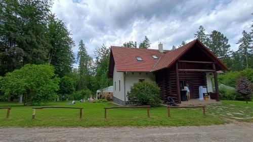 a small house with a red roof in the grass at Chata BABÍ LOM in Lelekovice