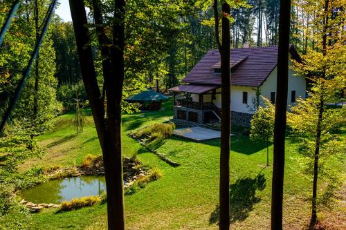 a house in the middle of a yard with a pond at Chata BABÍ LOM in Lelekovice