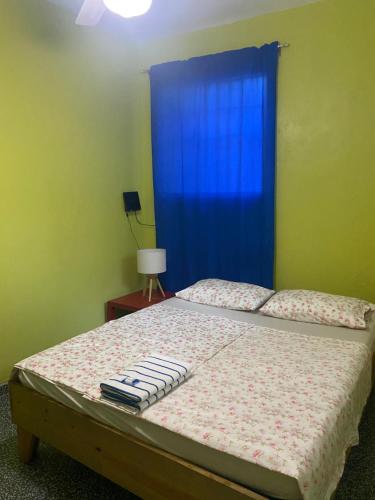 a bedroom with a bed with a blue curtain at Casa Azul - Apartment in San Felipe de Puerto Plata