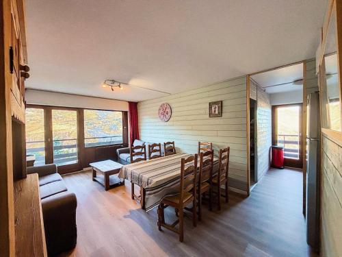 une salle à manger avec une table, des chaises et un canapé dans l'établissement Résidence Oisans - Appartement pour 10 personnes MAE-4001, aux Menuires