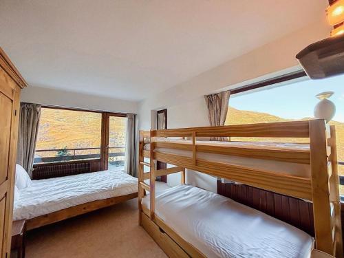 deux lits superposés dans une chambre avec une grande fenêtre dans l'établissement Résidence Oisans - Appartement pour 10 personnes MAE-4001, aux Menuires