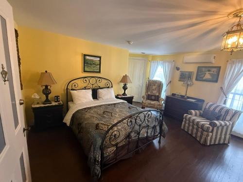 a bedroom with a large bed and a chair at The Gridley Inn B&B in Waterloo