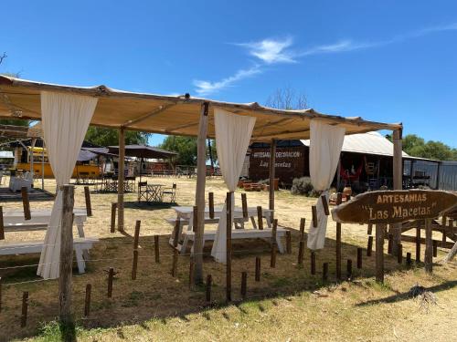 a pavilion with chairs and a surfboard under it at Duplex 1 Villa Ramallo in Estación Ramallo