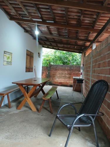 a patio with a table and chairs and a brick wall at Casa Recanto da Paz in Sao Jorge