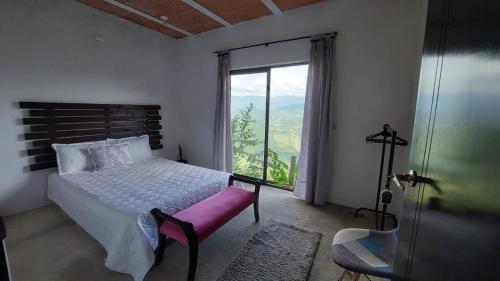a bedroom with a bed and a large window at Hostel Cielo y Tierra Vergara in Vergara