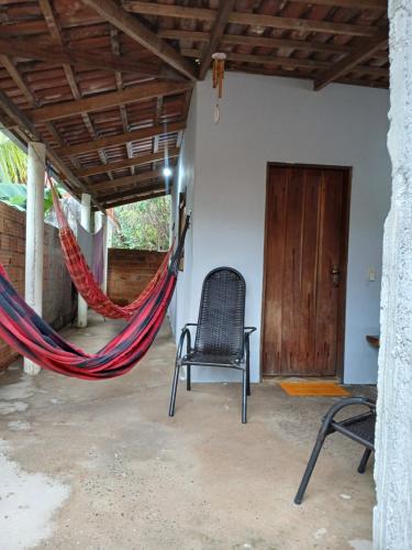 a hammock in a room with a chair and a door at Casa Recanto da Paz in Sao Jorge