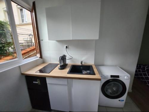 une petite cuisine avec un évier et une machine à laver dans l'établissement Appartement 2 pieces agréable lumineux et calme, à Gentilly