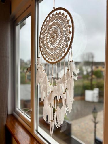 a dream catcher chandelier hanging from a window at Malahide Guest Rooms in Malahide