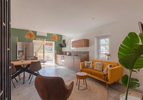un salon avec un canapé jaune et une cuisine dans l'établissement Duplex moderne à 5 min Aix, à Aix-en-Provence
