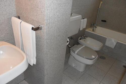 a bathroom with a toilet and a sink at Hotel Paulista in Porto