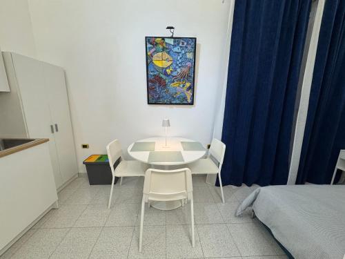 a room with a table and chairs and a bed at suite cubè al centro storico vicino la scuola Vespucci con parcheggio su richiesta in Frattamaggiore