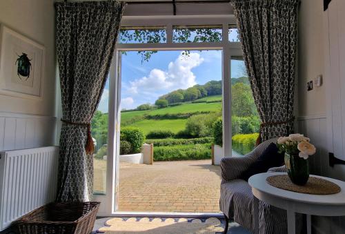 un salon avec une grande fenêtre avec vue dans l'établissement Keep Cottage, à Southleigh
