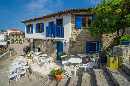 a group of tables and chairs in front of a building at Afitos Guest House in Afitos