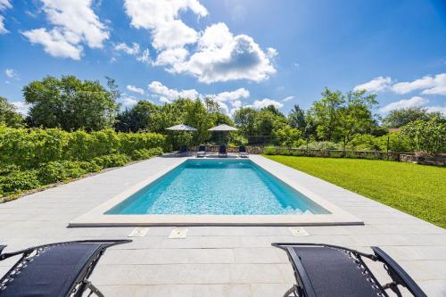 a swimming pool in a yard with chairs at Old Stone Villa Katarina in Nedeščina