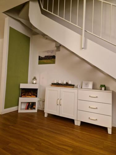 een zolderkamer met een witte kast en een trap bij Galeriewohnung Ritter Ramm mit kostenlosem Parkplatz und Kamin, Bahnhof fußläufig in Goslar