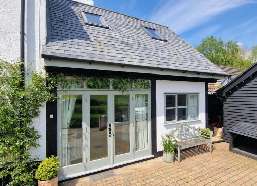 an extension to a house with sliding glass doors at Keep Cottage in Southleigh