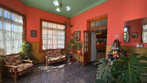 a living room with orange walls and a christmas tree in it at El Viejo in Río Mayo