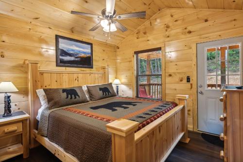 ein Schlafzimmer mit einem Bett in einer Blockhütte in der Unterkunft On Blackbeary Hill A cozy 3 BR cabin perfect for a getaway in an enchanting forest setting in Pigeon Forge