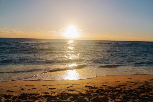 a sunset on a beach with the ocean at Cardozo Hotel in Miami Beach