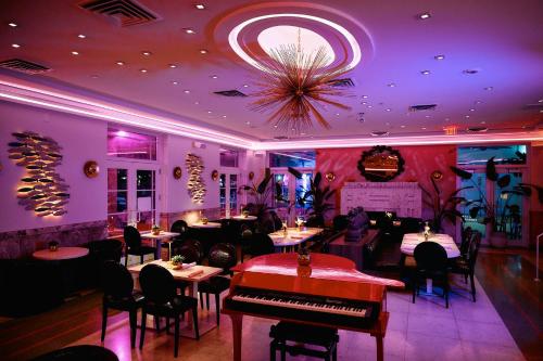 a restaurant with a piano and tables and chairs at Cardozo Hotel in Miami Beach