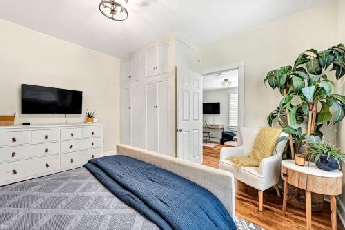 a bedroom with a bed and a dresser with a tv at Decca's Uptown Oasis in Siloam Springs