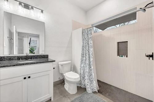 a white bathroom with a toilet and a sink at Decca's Uptown Oasis in Siloam Springs