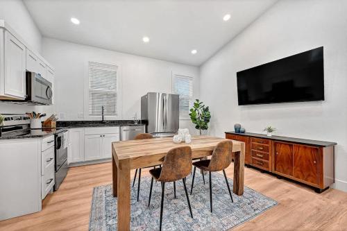 a kitchen with a wooden table and some chairs at Decca's Uptown Oasis in Siloam Springs