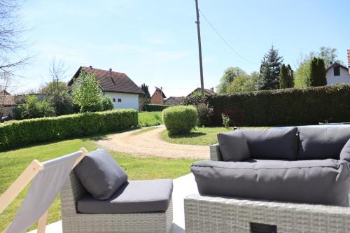 a patio with two couches and a chair at Elbe Holiday in Donja Stubica