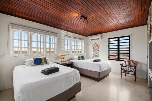 a bedroom with two beds and a wooden ceiling at Million dollar view Spanish Hacienda Style Luxury Villa in Jan Thiel in Jan Thiel