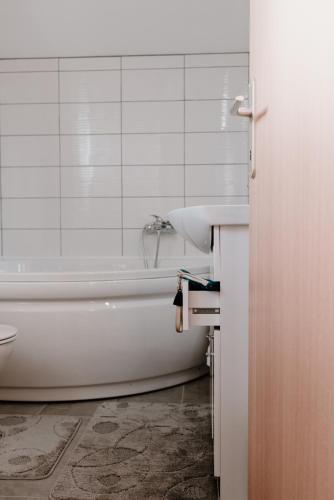 a bathroom with a white tub and a sink at Elbe Holiday in Donja Stubica