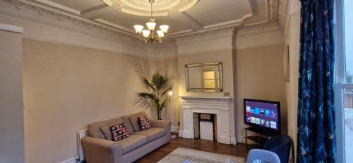 a living room with a couch and a television at Charming Flat in Wimbledon in London