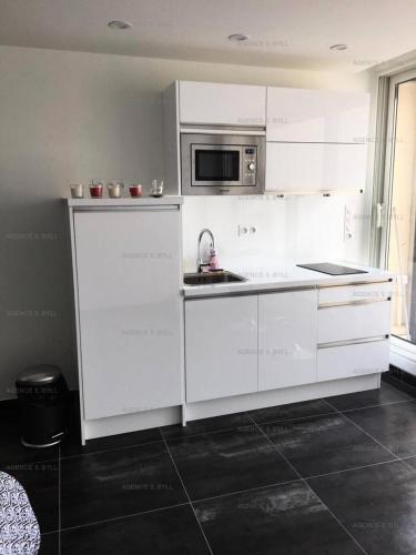 une cuisine blanche avec un évier et un micro-ondes dans l'établissement Résidence Héliopolis Bâtiment K - Studio 2 pers. Héliopolis K MAE-4604, au Cap d'Agde