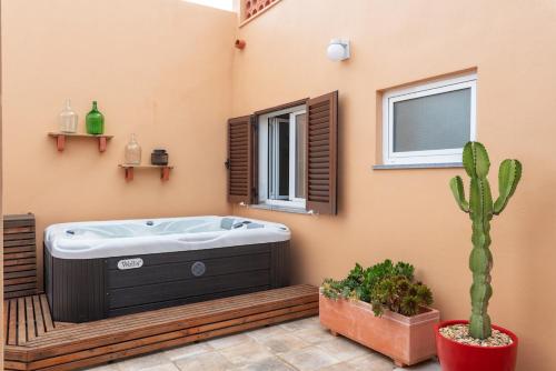 a bathroom with a soaking tub and a cactus at Casa Arte 5 in Aljezur