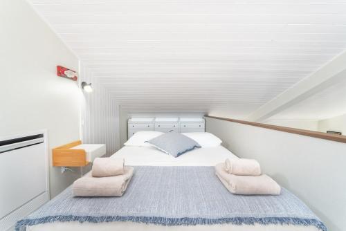 a white bedroom with a bed and two chairs at Casa Arte 5 in Aljezur